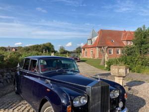 ein blaues Auto, das vor einem Haus parkt in der Unterkunft Nordpalais vor Sylt in Emmelsbüll-Horsbüll