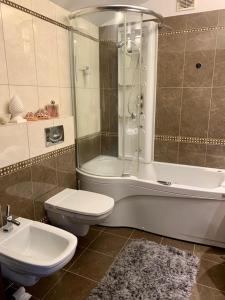 een badkamer met een bad, een toilet en een douche bij Apartament Panorama Ustronia in Ustroń
