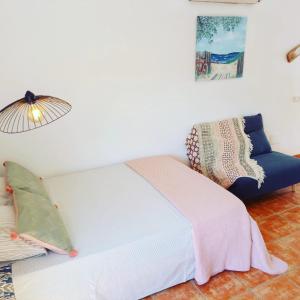 a bedroom with a bed and a lamp and a couch at Agua Amarga Design in Agua Amarga