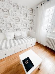 a white room with a couch and a wall with writing at La Capitainerie in Cancale