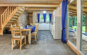 a kitchen and dining room with a table and chairs at Domki Bieszczady - Baza uŚmiechów in Ustrzyki Dolne