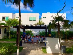 un grupo de personas sentadas en una mesa en un patio en Boutique House Cancun by Elevate Rooms, en Cancún