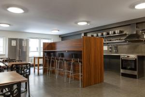 uma cozinha com um bar com cadeiras e mesas em Göteborgs Mini-Hotel em Gotemburgo