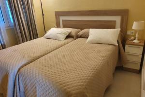 a bedroom with a large bed with two pillows at Familiar y luminoso apartamento exclusivo. in Marbella