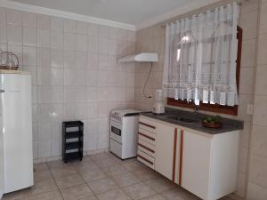 a small kitchen with a sink and a dishwasher at Apartamento Confortável in Marechal Floriano