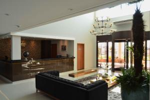 a living room with a couch and a chandelier at Hotel Matão By Mercure in Matão