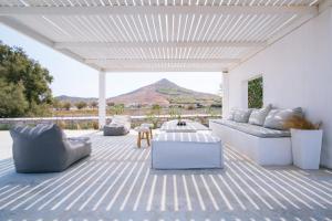 a patio with white furniture and a view of a mountain at Molos Beachfront Villa in Molos Parou