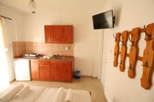 uma cozinha com um sofá branco e uma televisão num quarto em SARTI CENTER studios em Sarti