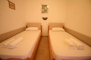 2 posti letto in una piccola stanza con asciugamani di SARTI CENTER studios a Sárti