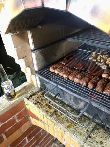 a grill with sausages and other food on it at Cabana Baraj Apuseni Mountains in Mihoeşti