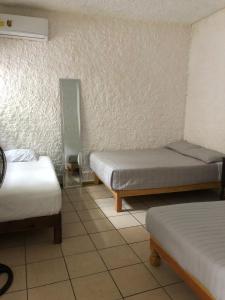 Ένα ή περισσότερα κρεβάτια σε δωμάτιο στο Hotel Perla Mazatlan