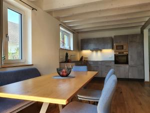 cocina y comedor con mesa de madera y sillas en Ferienhaus am Funkenbühl en Salem