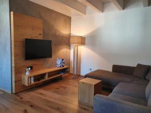 a living room with a couch and a flat screen tv at Ferienhaus am Funkenbühl in Salem