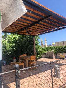 un patio con mesa, sillas y una valla en Hotel Perla Mazatlan, en Mazatlán