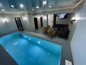 een groot blauw zwembad in een kamer met een eetkamer bij Hotel Terrazzo in Starunya