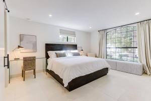 a bedroom with a large bed and a large window at Casa Valerio - Boutique Suites in Downtown Santa Barbara in Santa Barbara