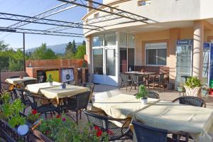 eine Terrasse mit Tischen und Stühlen und einem Kamin in der Unterkunft Apartments Murati in Ulcinj