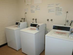 3 lavadoras están alineadas en una habitación en Launceston Backpackers en Launceston