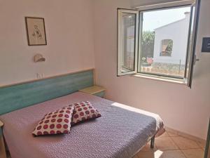 a bedroom with a bed with a pillow and a window at Case Vacanza Raffaela Disanti in Vieste