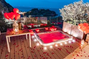 a hot tub on a deck with a view at Isola Bella Infinity Suites in Taormina