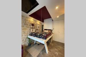 une chambre avec un lit et une table avec des oreillers dans l'établissement Tiny Gallery Paris Gare Montparnasse, à Paris