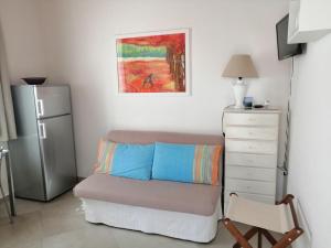 1 dormitorio con sofá, cómoda y nevera en Punta Palivi, en Mattinata