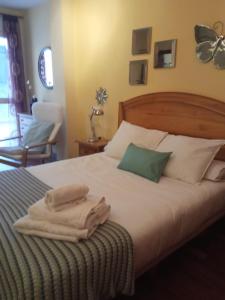 a bedroom with a bed with towels on it at Apartamento en Viveiro (Casco histórico) in Viveiro