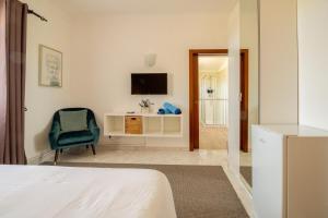 a bedroom with a bed and a tv and a chair at Quinta Nova Vale Del Rey in Carvoeiro