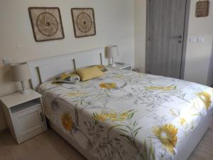 een slaapkamer met een bed met een bloemenbed bij Numar Residence J -Manta Rota in Manta Rota +26 foto's