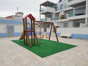 un parque infantil con un tobogán sobre una alfombra verde en Numar Residence J -Manta Rota, en Manta Rota