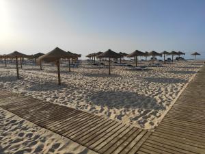 een strand met parasols en stoelen op het zand bij Numar Residence J -Manta Rota in Manta Rota