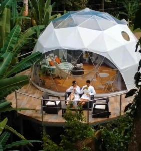 
a man sitting on top of a boat with an umbrella at Faith Glamping Dome Costa Rica in Manzanillo

