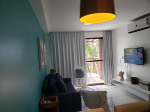 sala de estar con sofá azul y ventana en Barra Bali - Luxo e Paraiso, en Barra de São Miguel
