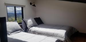 Duas camas num quarto com uma janela em Peñavista. em Simijaca