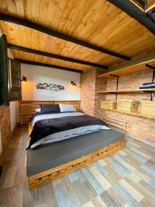 una camera con un grande letto in un muro di mattoni di Peñavista. a Simijaca