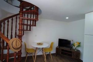 Habitación con mesa, sillas y escalera. en Cantinho D'aldeia - Casa Rural com Jacuzzi, en Guarda