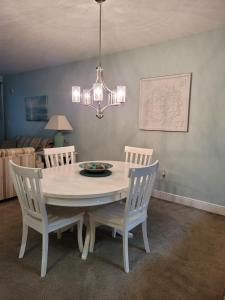 a dining room table with two chairs and a chandelier at 122 Seascape Drive, Unit 1409 in Destin