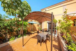 een patio met een tafel en een parasol bij Remarkable 2-Bed House in Arona in Arona