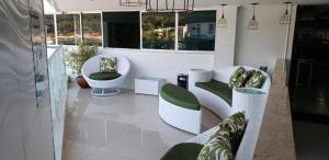 ein Wohnzimmer mit weißen Stühlen und einem Sofa in der Unterkunft Angra inn, Angra dos Reis in Angra dos Reis