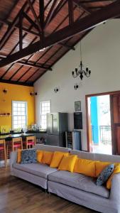 een woonkamer met een bank en een keuken bij Casa de campo Recanto Pedra Azul in Baependi