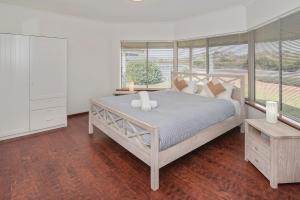 a bedroom with a large bed and a large window at Bella Beach House Prevelly 50m from the beach in Prevelly