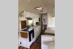 an rv kitchen with white cabinets and appliances at Amazing Airstream, Beaufort, SC-Enjoy the Journey in Beaufort