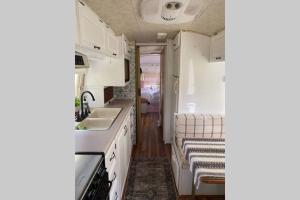 a kitchen with white cabinets and a sink at Amazing Airstream, Beaufort, SC-Enjoy the Journey in Beaufort