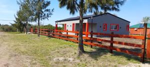 a house with a fence in front of it at UBUNTU in Concepción del Uruguay