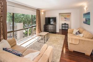 a living room with two couches and a large window at Down Town Margaret River in Margaret River Town