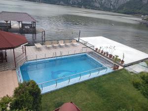 a large swimming pool next to a body of water at Casa Lucian in Dubova