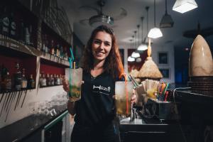科内西庇斯克斯酒店的站在酒吧喝一杯的女人
