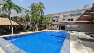 a large blue swimming pool in front of a building at DNA Cancun Hotel y Posada in Cancún