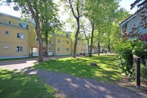 a park with trees and green grass and buildings at Majoitushuoneisto Tuomipuisto in Naantali