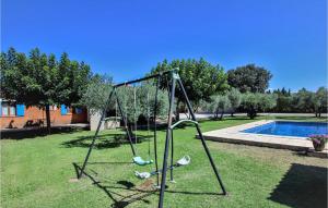 a swing set in a yard next to a pool at Cozy Home In Carpentras in Carpentras